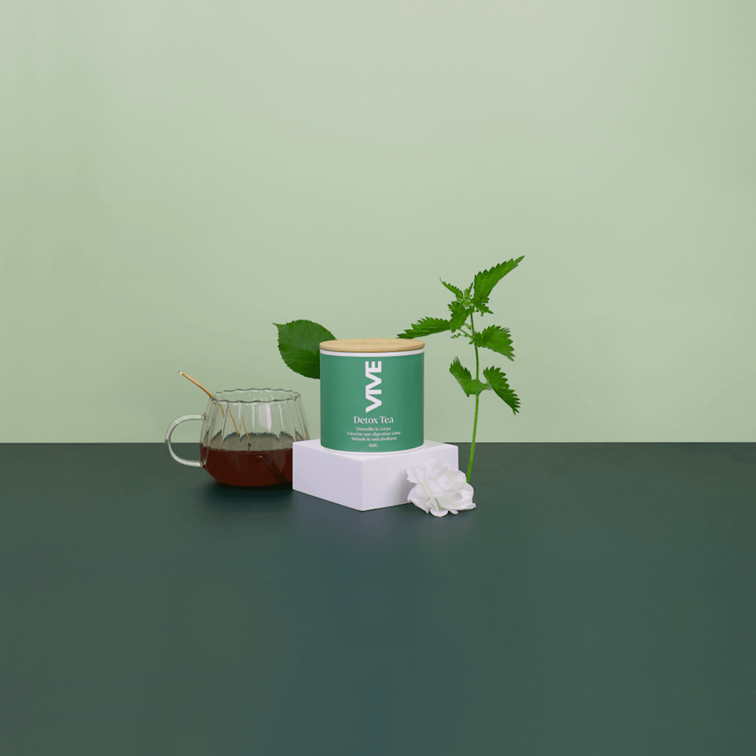 Boîte de Detox Tea avec infusion dans une tasse, plante verte et fleur sur fond minimaliste.