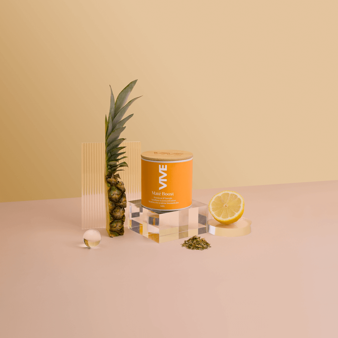 Maté Boost infusion énergisante naturelle, avec ananas et citron sur fond pastel, parfaite pour une tasse de thé revitalisante.