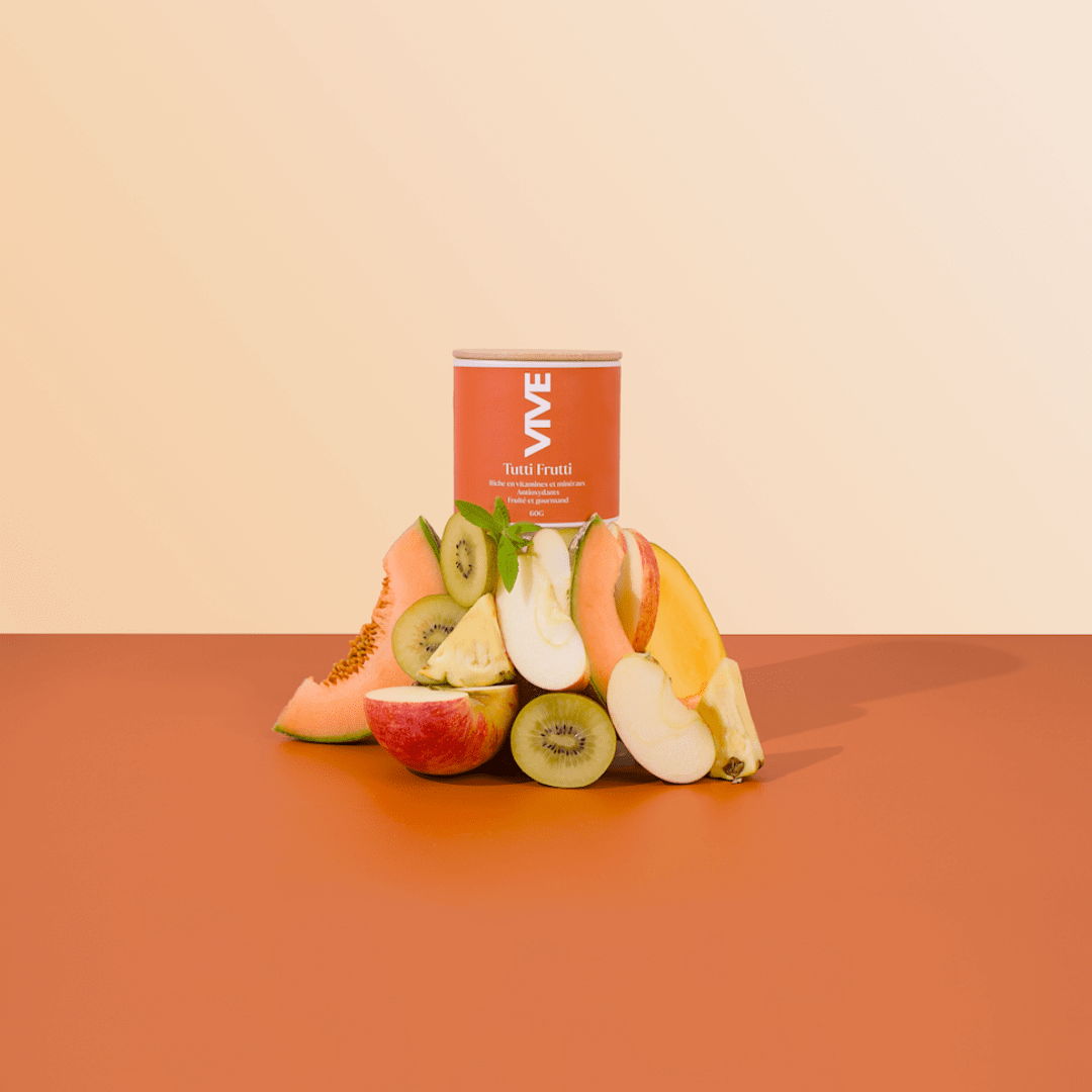 Tutti Frutti infusion tea can with fresh tropical fruits like mango, kiwi, and melon on a warm orange background.